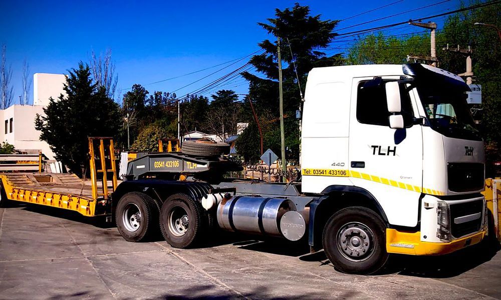 Camión batea transportando maquinaria